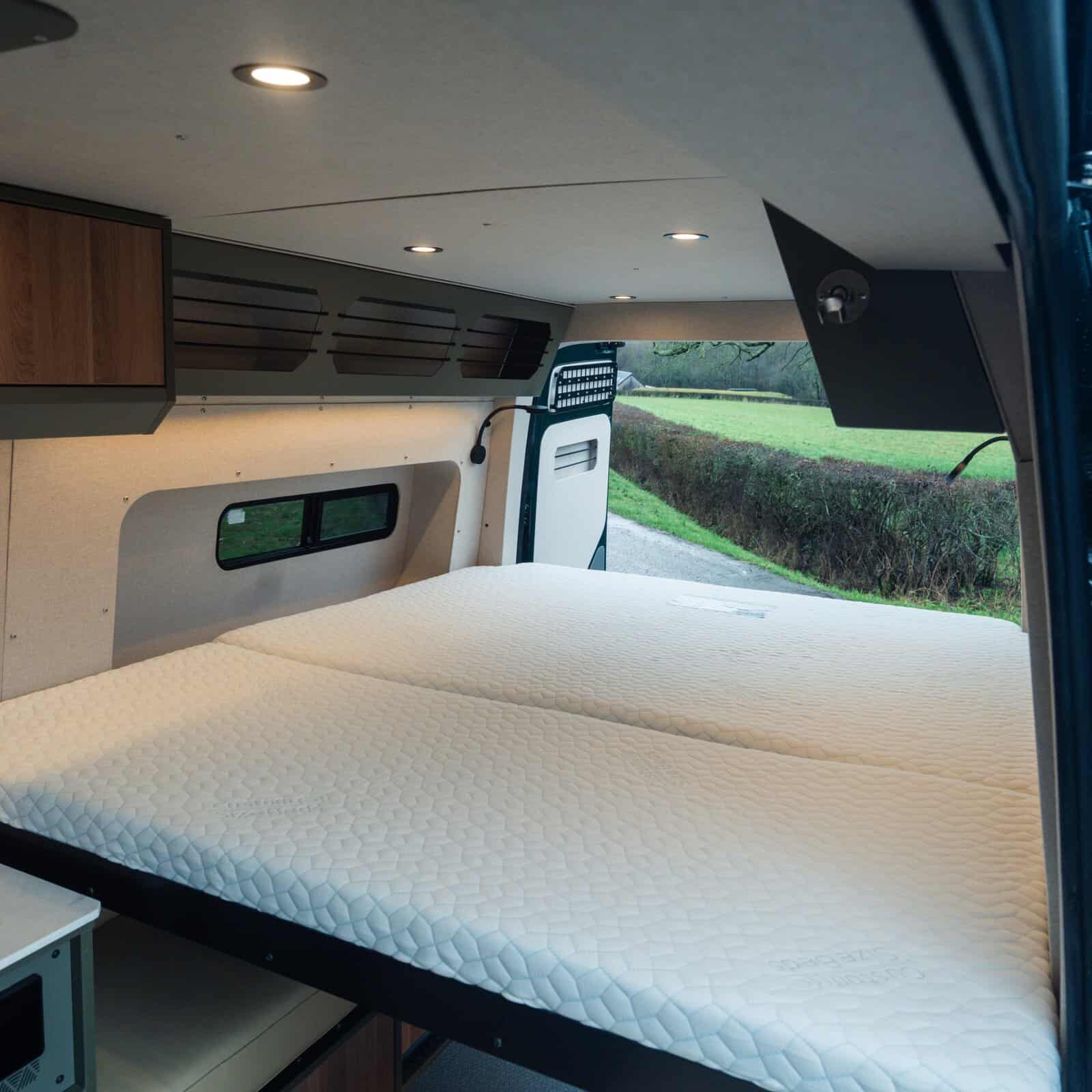 Aluminium sliding super-king bed inside the Onyx Summit MAN TGE campervan