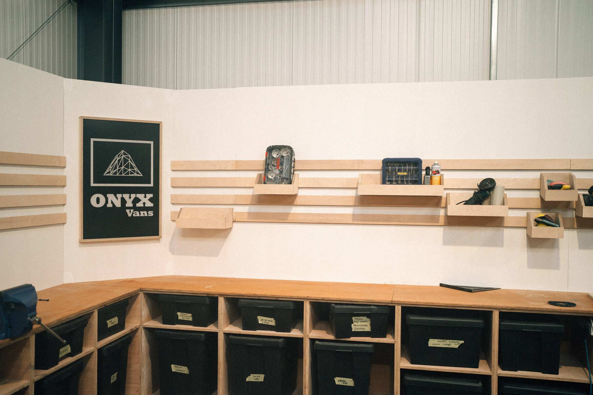 The tool wall at the Onyx Vans workshop in West Sussex, with plywood shelving and labelled parts bins