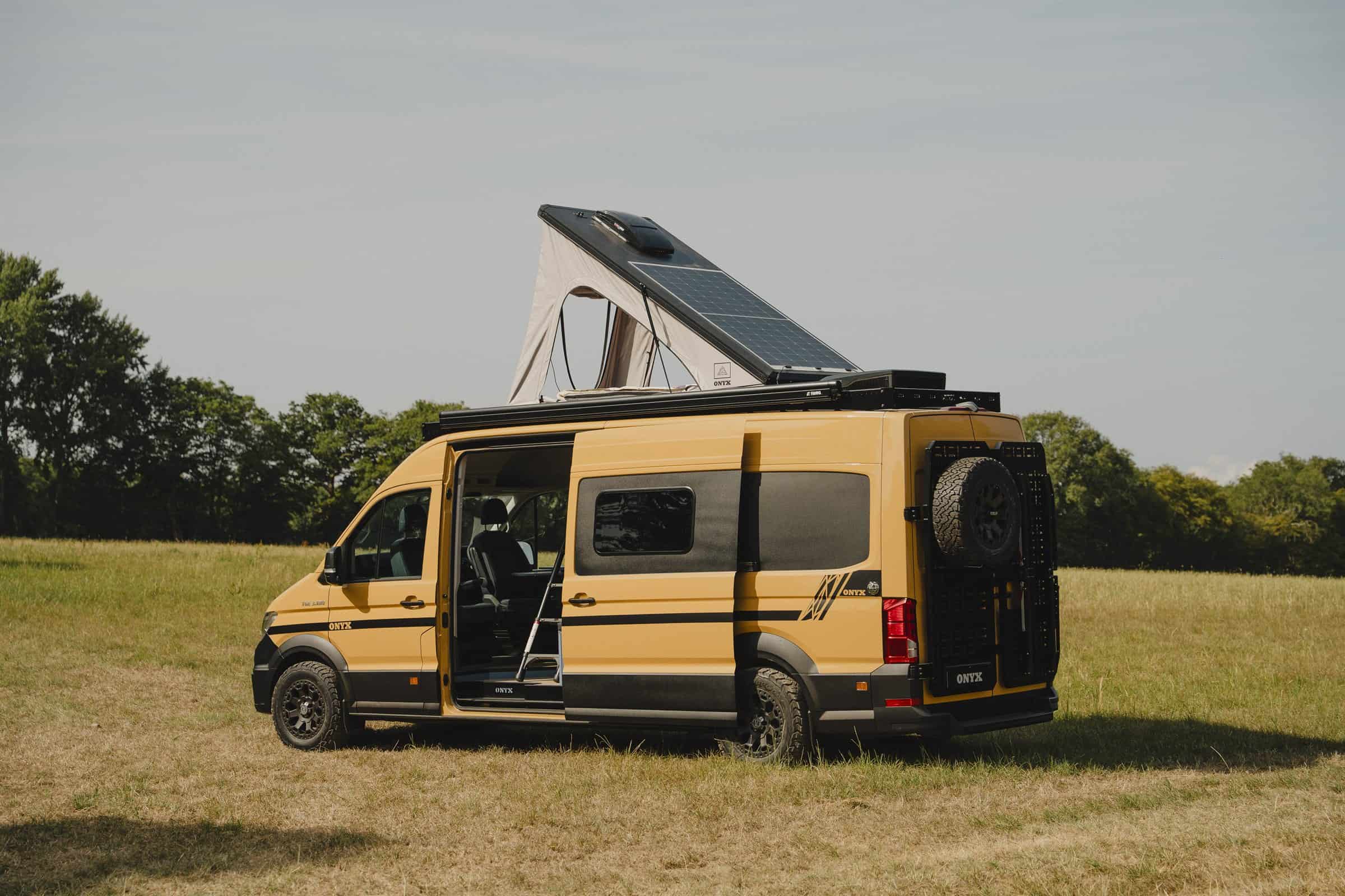 The Onyx Outpost parked in a field with the pop-top raised