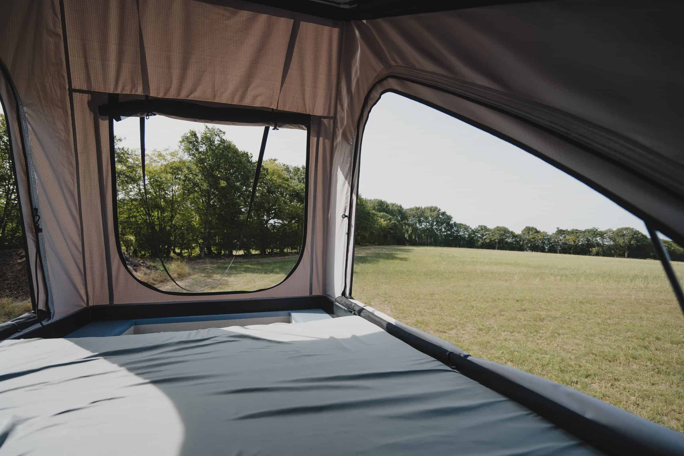 Inside the raised pop-top upper berth of the Onyx Mesa, mattress made up