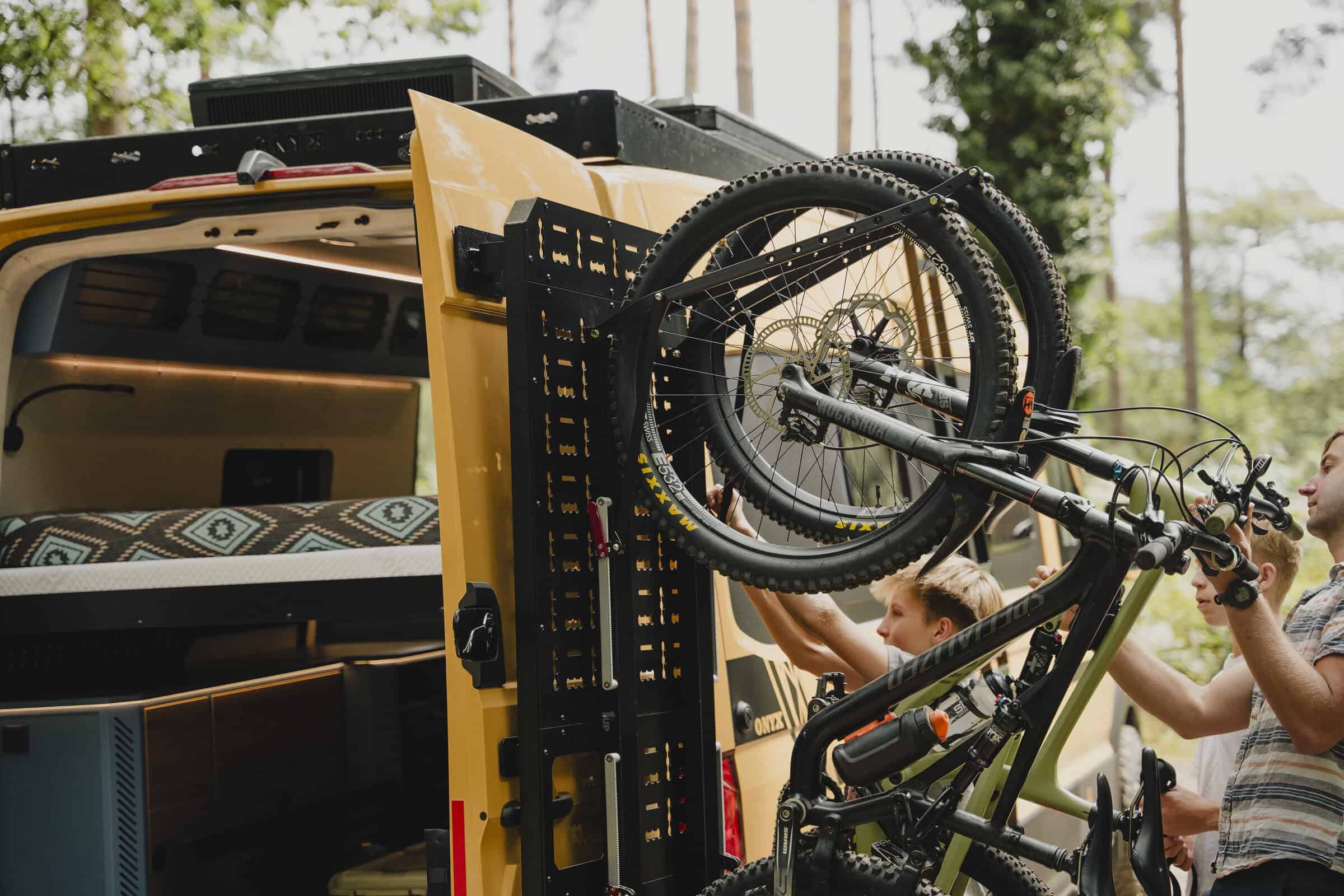 Loading a mountain bike onto the rear carrier of the Onyx Outpost campervan