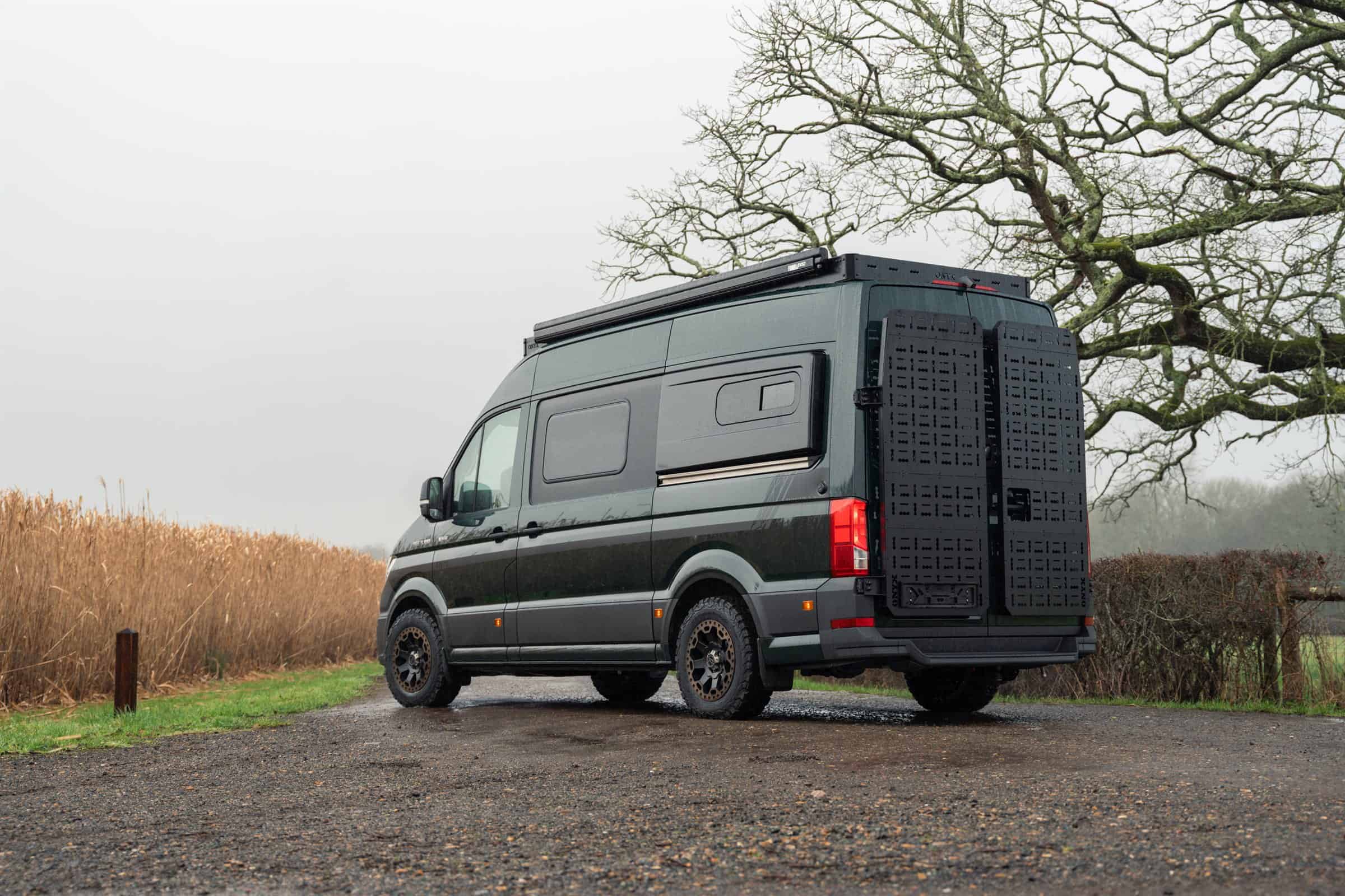 Rear three-quarter view of an Onyx van showing the roof rack and a rear door storage panel