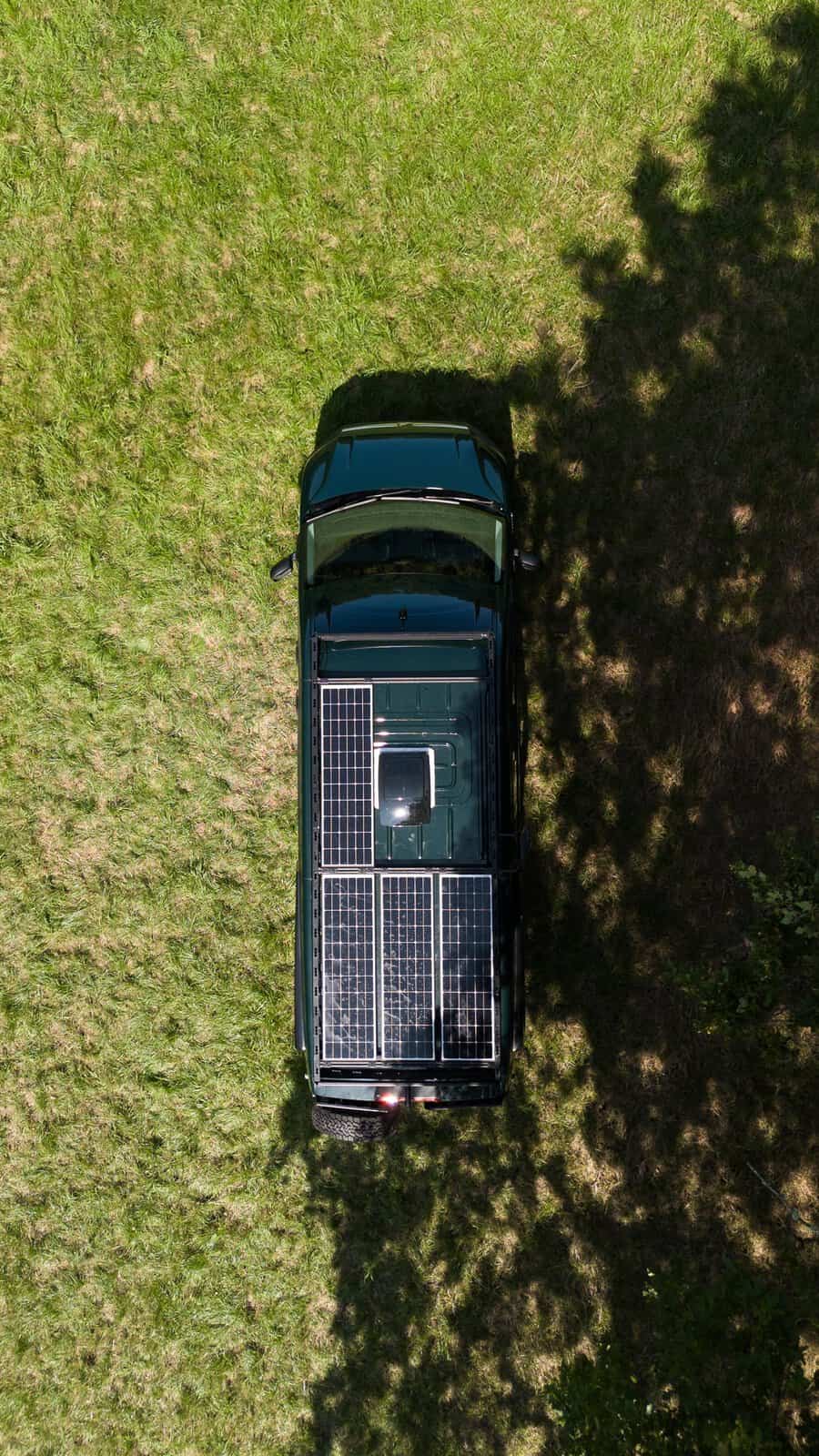 Looking down on an Onyx roof rack carrying three solar panels across the full length of the roof