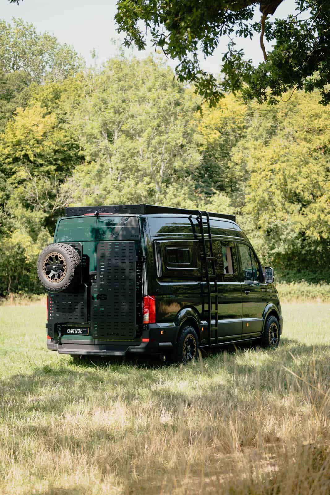 Rear three-quarter view showing the Onyx side ladder and both rear door carriers, one holding a spare wheel