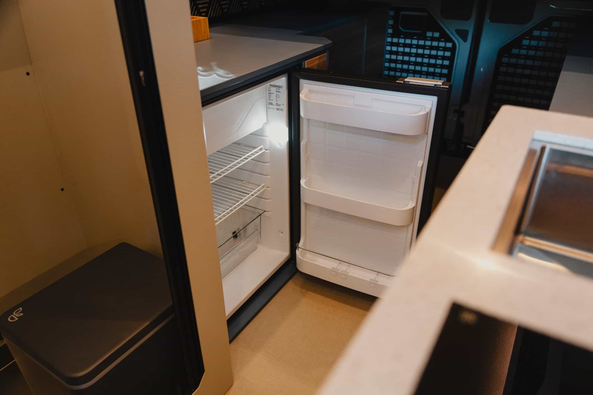 The 85l compressor fridge in the Onyx Mesa with its door open, showing the shelves and door storage