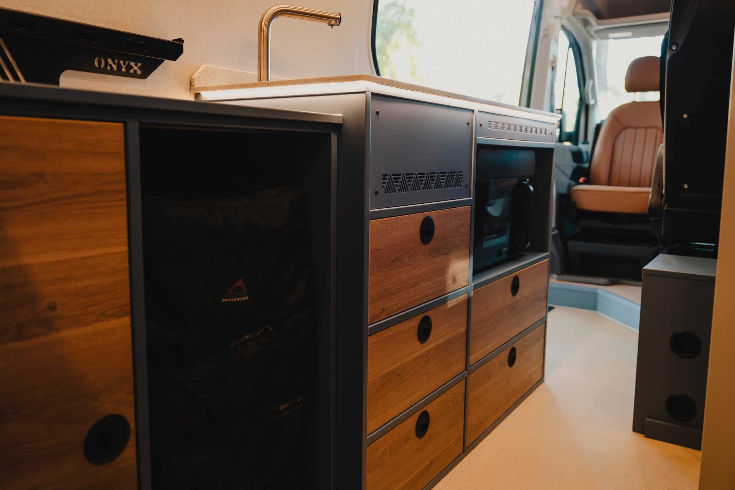 Kitchen unit in the Onyx Mesa with wood-finish drawers, powder-coated aluminium frame and the optional three-in-one oven