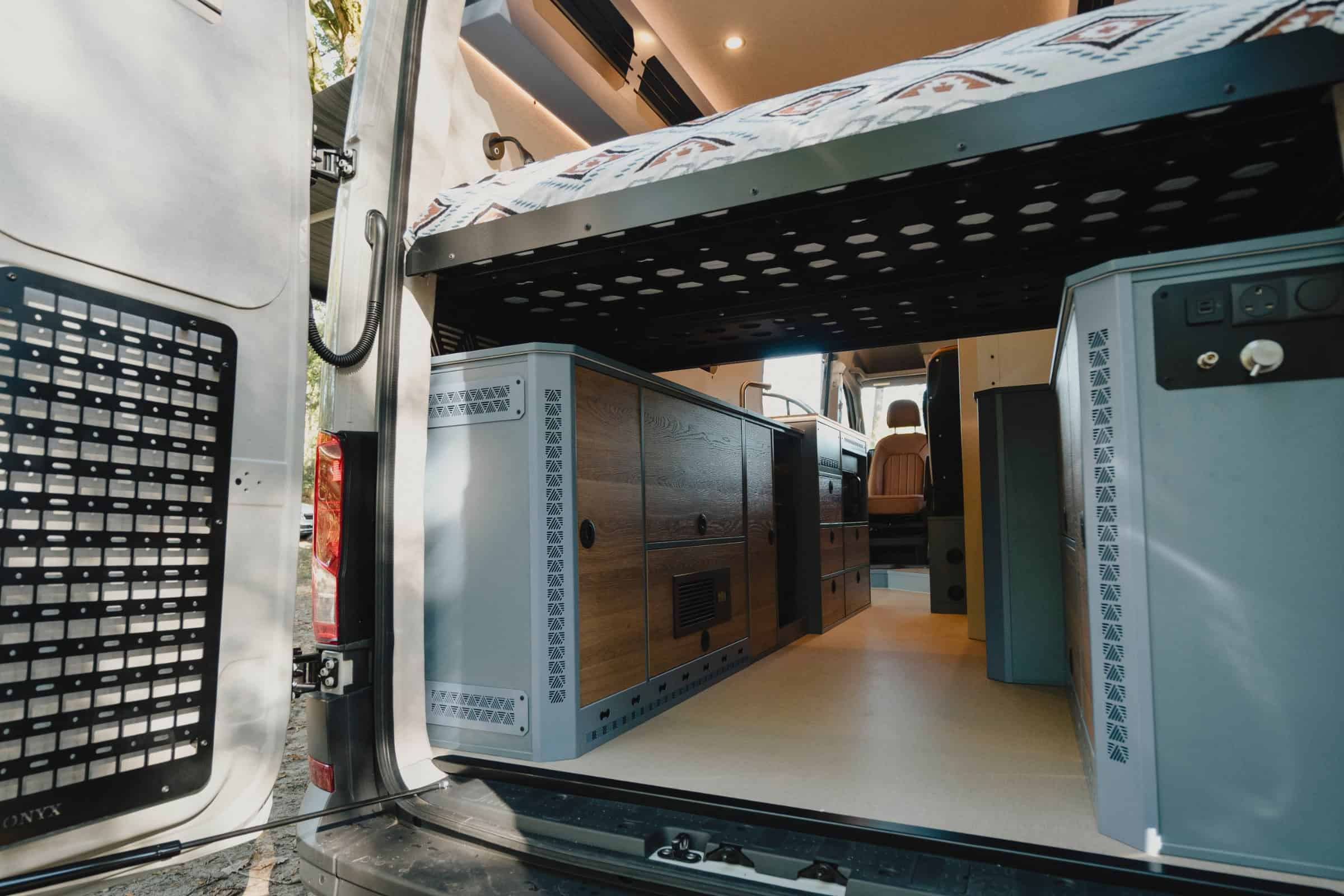 Rear doors open on the Onyx Mesa, showing the open-through garage under the bed and the storage panel on the door
