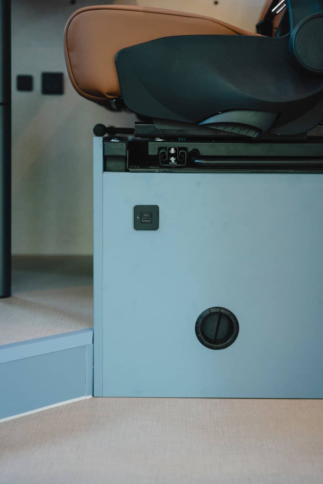 Warm-air heating outlet in the seat base of the Onyx Mesa, with a USB charging socket above