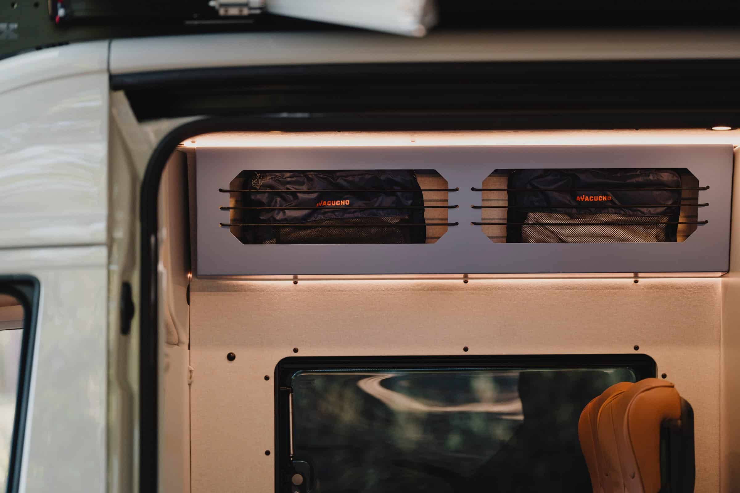 Overhead storage lockers with bungee retainers in the Onyx Mesa, seen through the side door