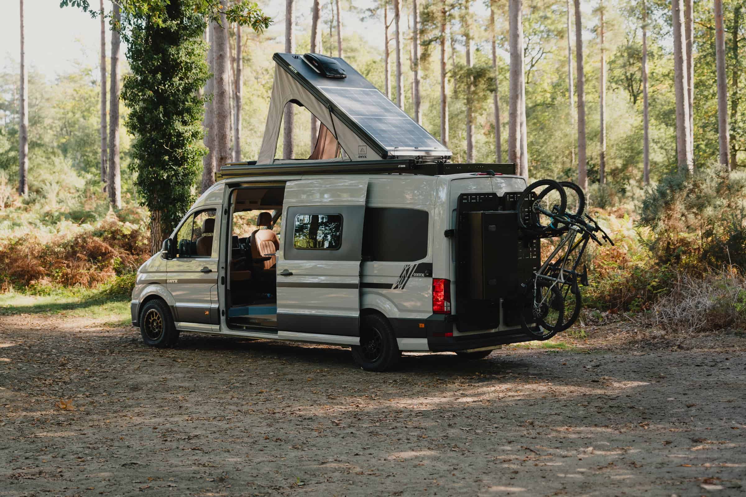 The Onyx Mesa from the rear three-quarter with pop-top raised, solar panel, rear carriers, storage box and bikes