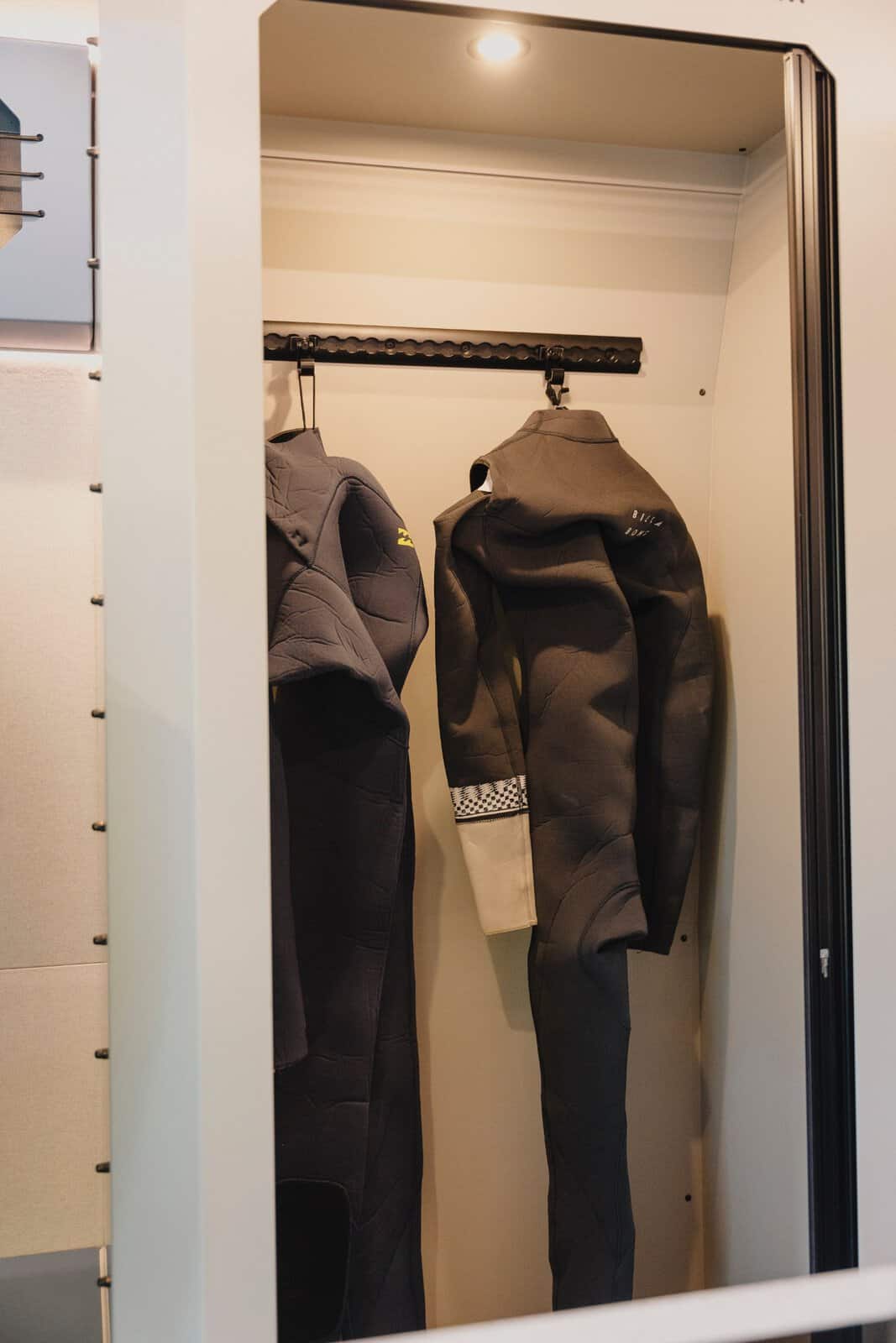 Wetsuits hanging to dry in the shower room of the Onyx Mesa
