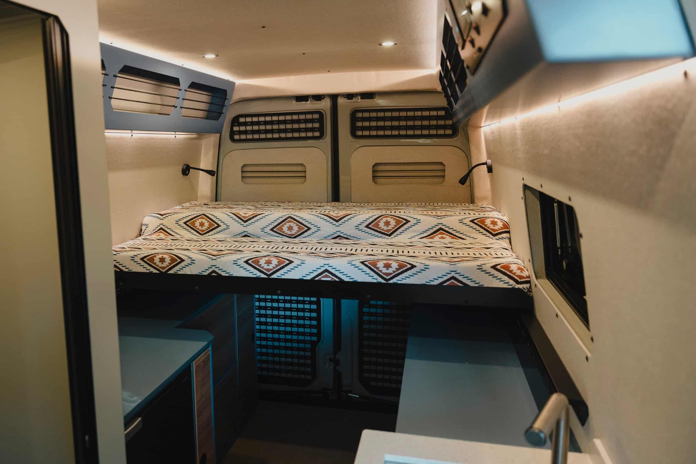 King-sized sliding bed tucked away at the rear of the Onyx Mesa, with overhead lockers and reading lights